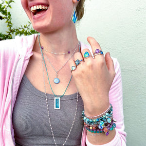 model wearing layered up cancer bracelets, necklaces, earrings and rings for disease awareness