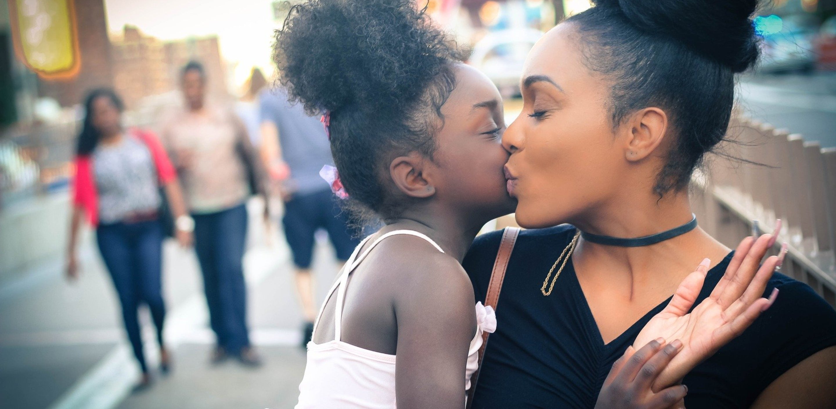 mother giving daughter a kiss on the cheek