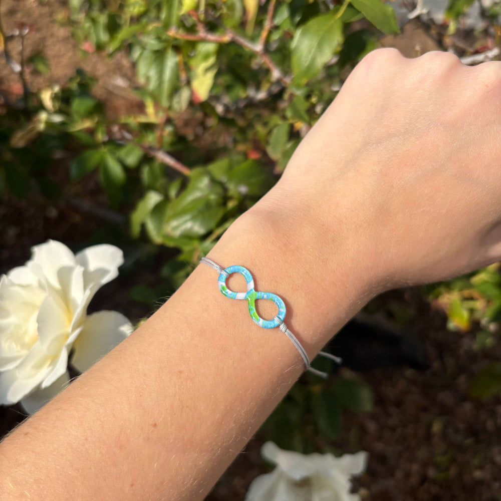 model wearing Alzheimer's cell image infinity symbol pendant with gray adjustable cord and Sterling silver slide bead