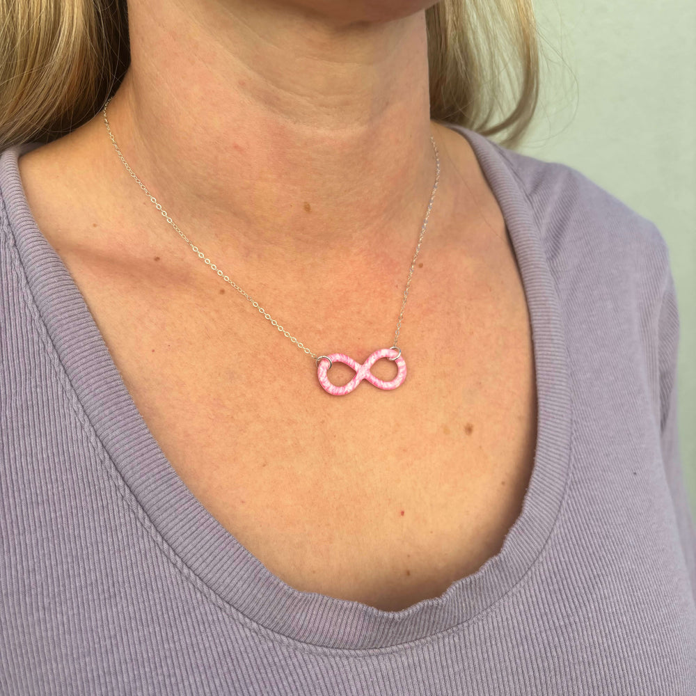 model wearing pink breast cancer cell image infinity symbol pendant with resin and Sterling silver chain necklace