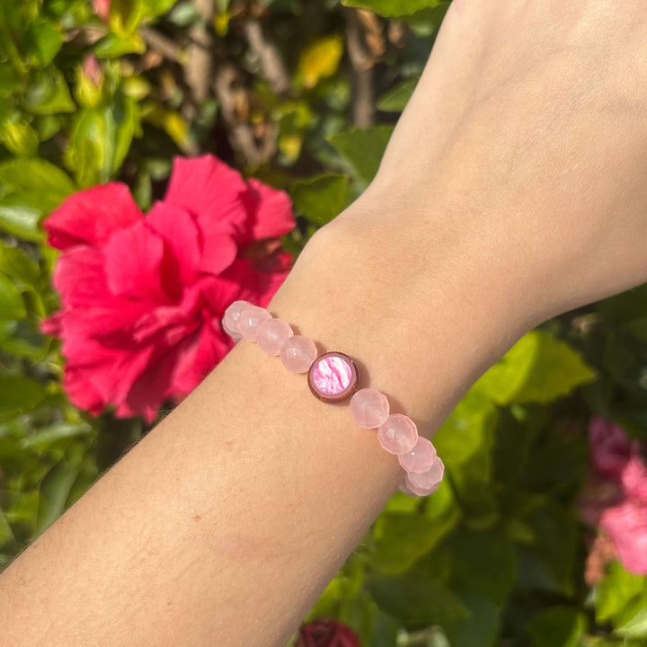 rose quartz stone stretch bracelet with breast cancer cell image in resin pendant on model