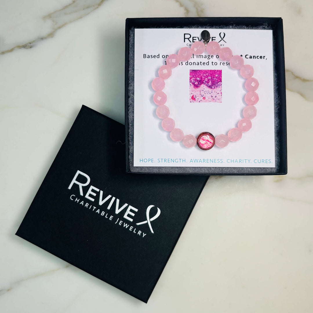rose quartz stone stretch bracelet with breast cancer cell image in resin pendant with product packaging
