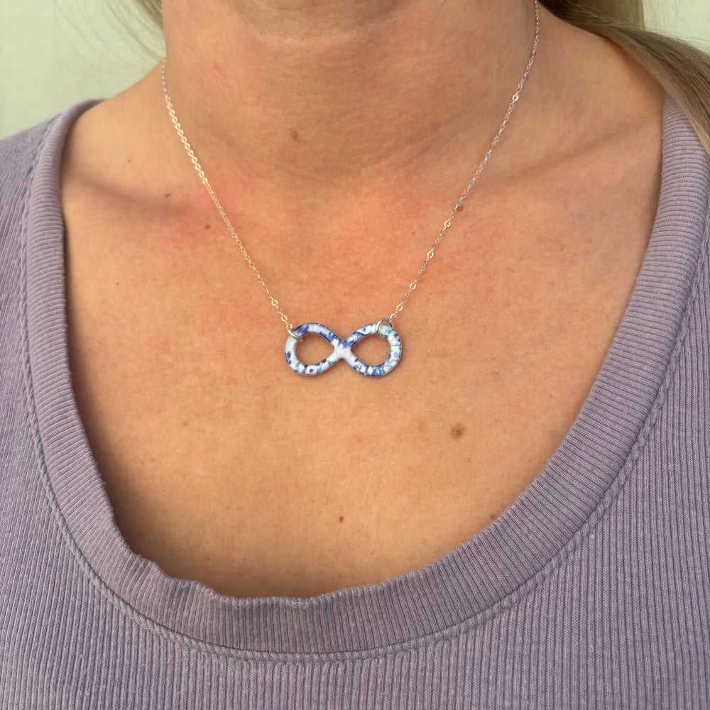 model wearing infinity symbol necklace based on a colon cancer cell image in resin with Sterling silver chain 