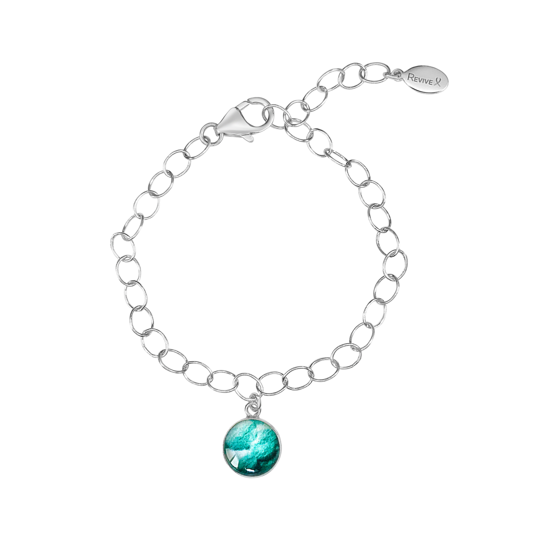 Silver chain bracelet with teal pendant showing embryo image on a white background