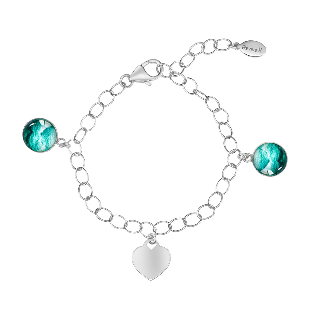 Silver bracelet with teal embryo images and a blank heart-shaped charm on a white background