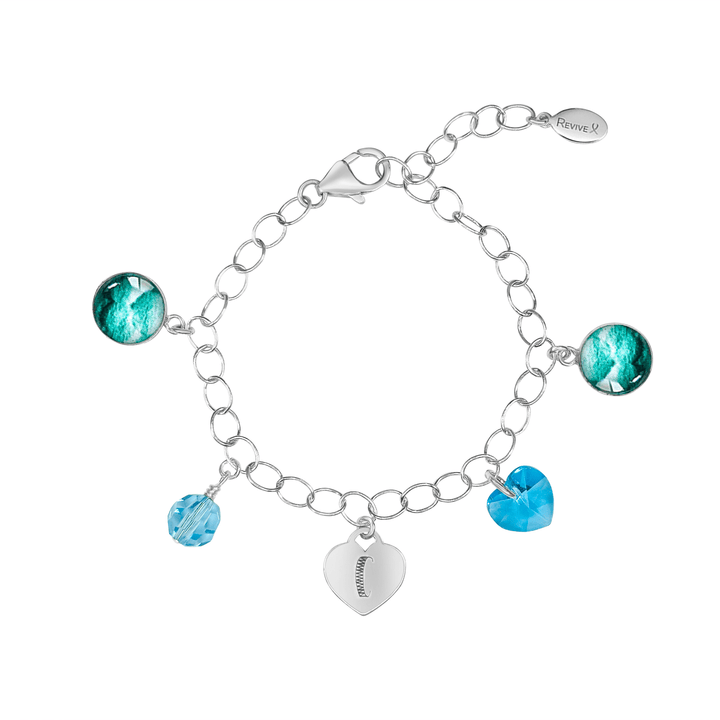 Silver bracelet with teal embryo images with blue crystals and a heart-shaped charm engraved with "C" on a white background