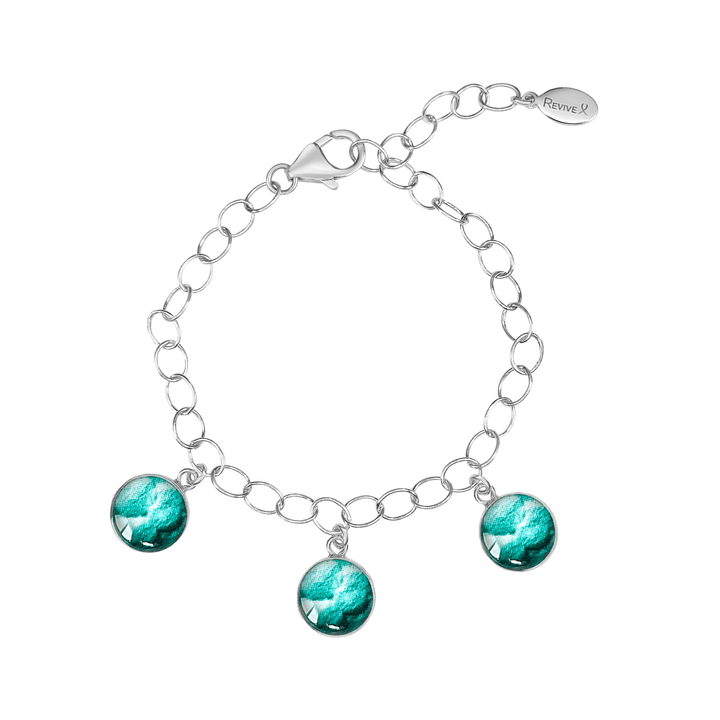 Silver bracelet with teal embryo images  on a white background