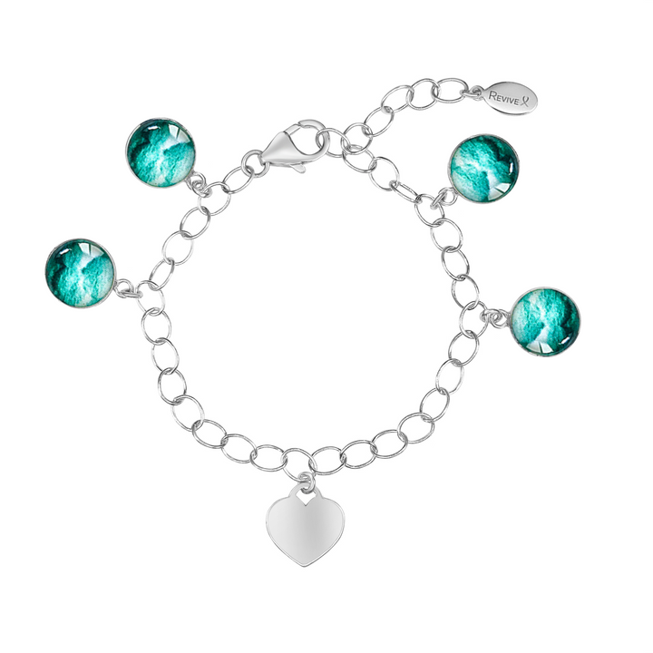 Silver bracelet with teal embryo images and a blank heart-shaped charm on a white background