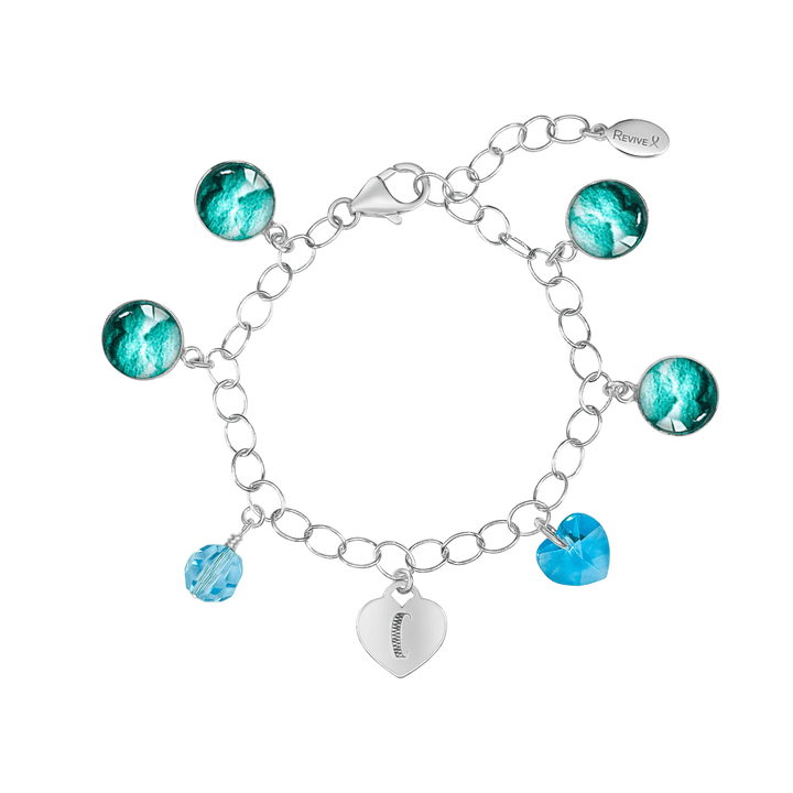 Silver bracelet with teal embryo images with blue crystals and a heart-shaped charm engraved with "C" on a white background