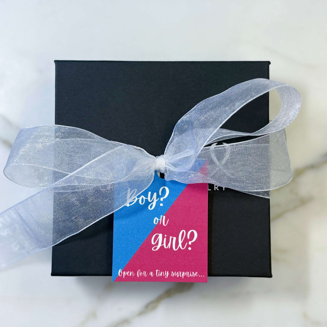 Gender Reveal Gift Product Packaging with Blue and Pink "Boy? or Girl? Open for a tiny surprise..." and a white ribbon.