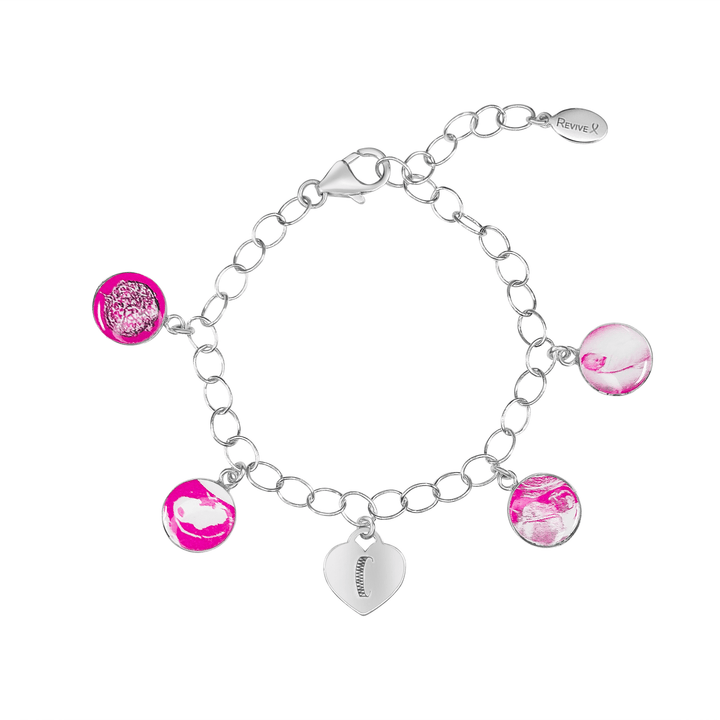Silver bracelet with pink pendants showing the IVF journey from embryo to baby and an engraved heart-shaped charm on a white background