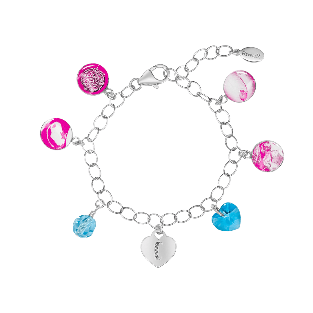 Silver bracelet with pink pendants showing the IVF journey from embryo to baby with blue birthstone crystals and an engraved heart-shaped charm on a white background