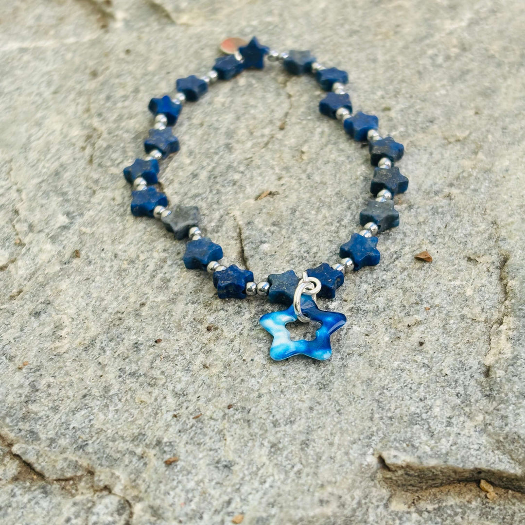 Star-shaped blue and silver bracelet on a textured surface