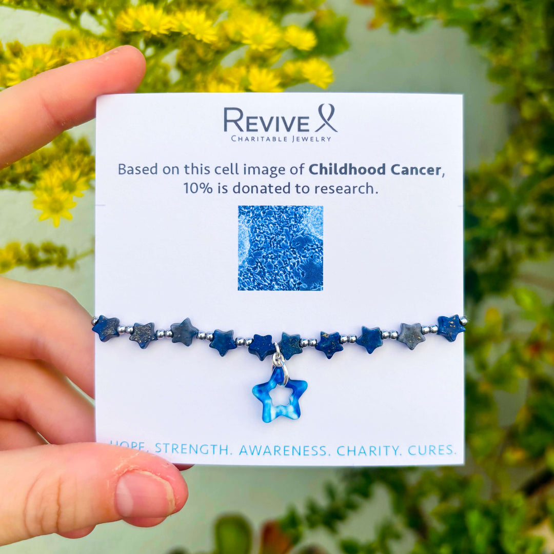Blue star bracelet on a card with 'Revive Charitable Jewelry' branding, held against a natural background.