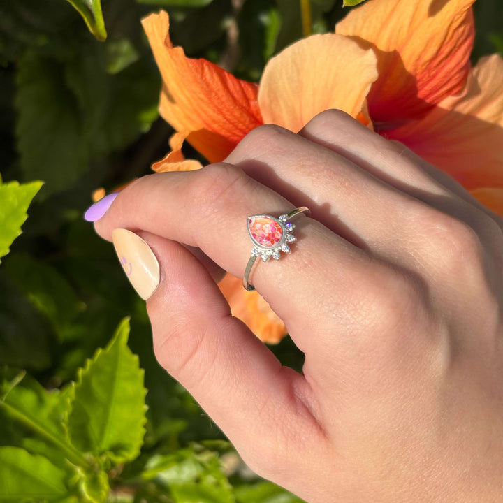 Sterling silver teardrop shaped ring with half halo of cubic zirconia stones and leukemia cell image under resin pendant on model