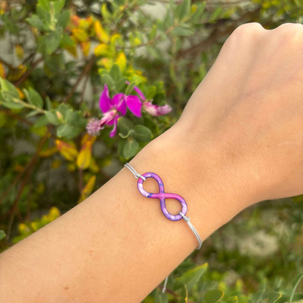 model wearing infinity pendant necklace with lung cancer cell image in resin on adjustable gray cord with Sterling silver slide bead clasp 