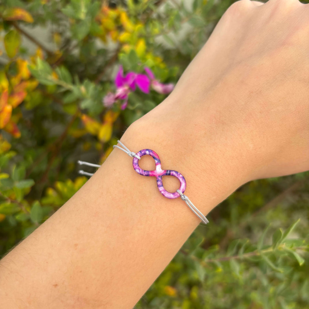 model infinity pendant bracelet with lupus cell image in resin on adjustable gray cord with Sterling silver slide bead 