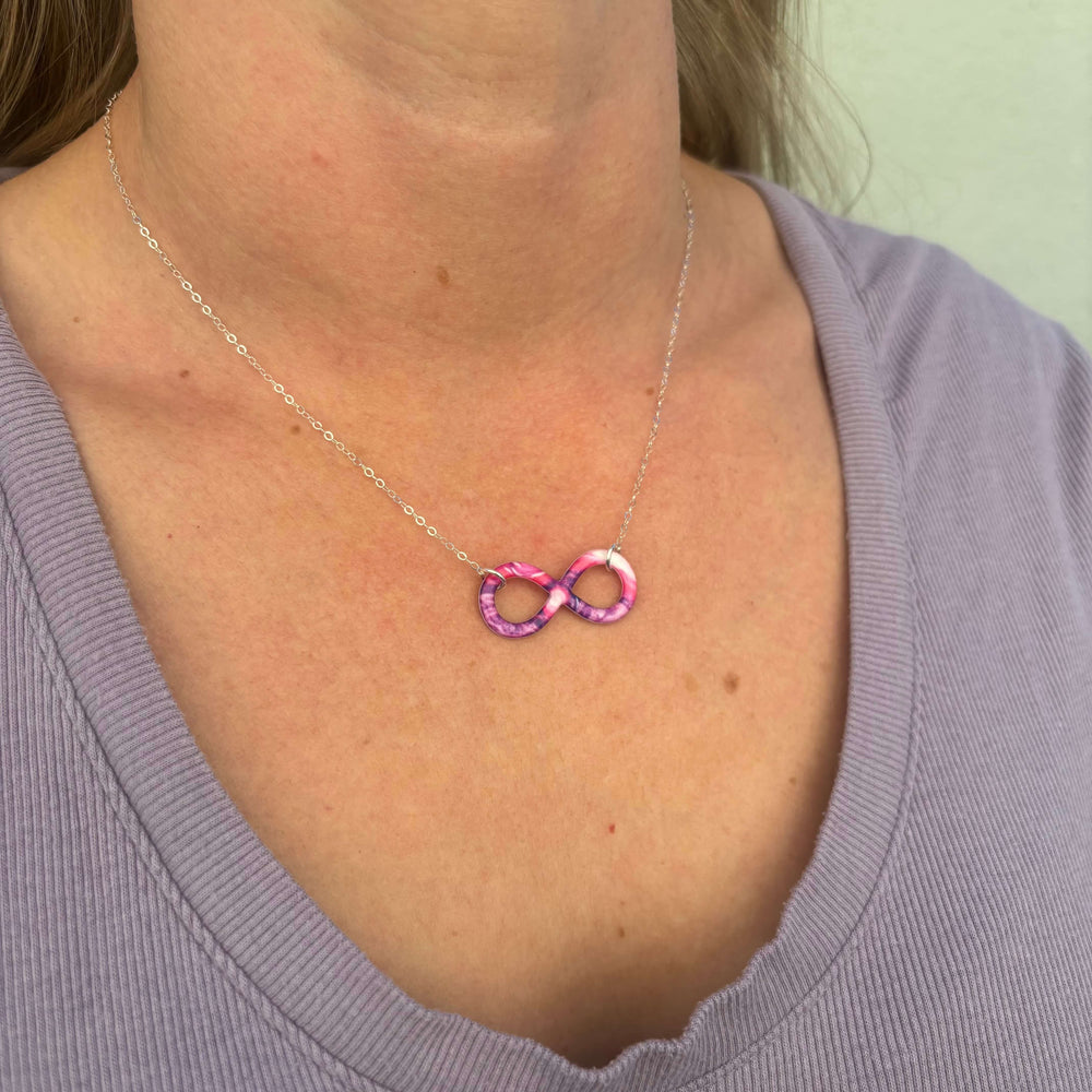 model wearing infinity pendant necklace with lupus cell image in resin on Sterling silver chain 