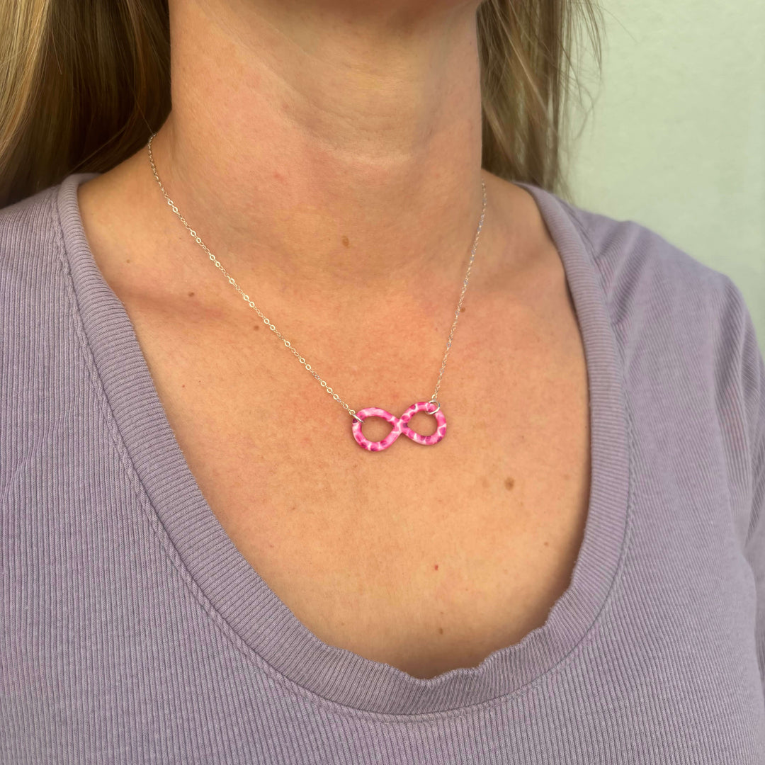 model wearing infinity pendant necklace with multiple Myeloma cell image in resin on Sterling silver adjustable chain 