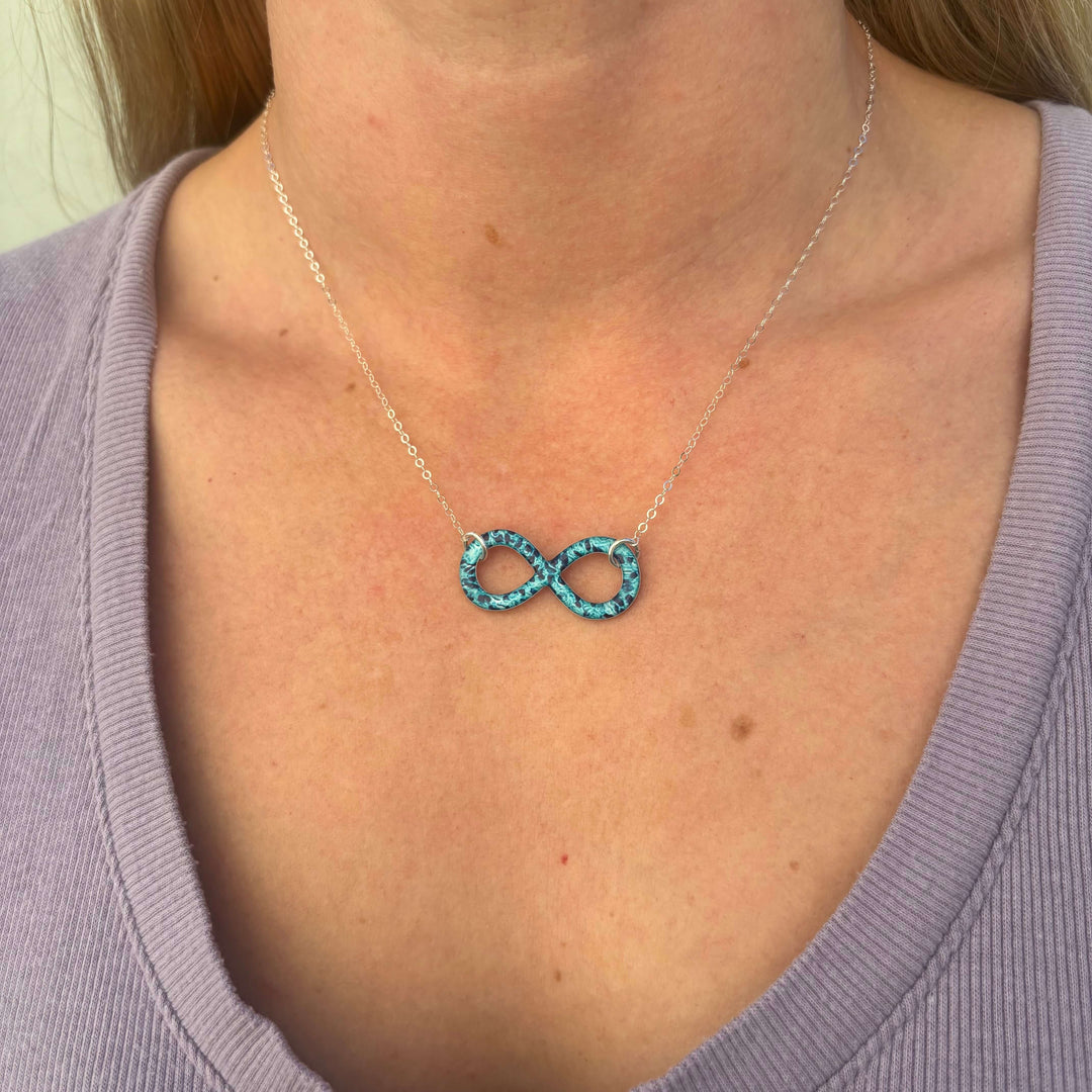 model wearing infinity pendant necklace with ovarian cancer cell image in resin on sterling silver adjustable chain 