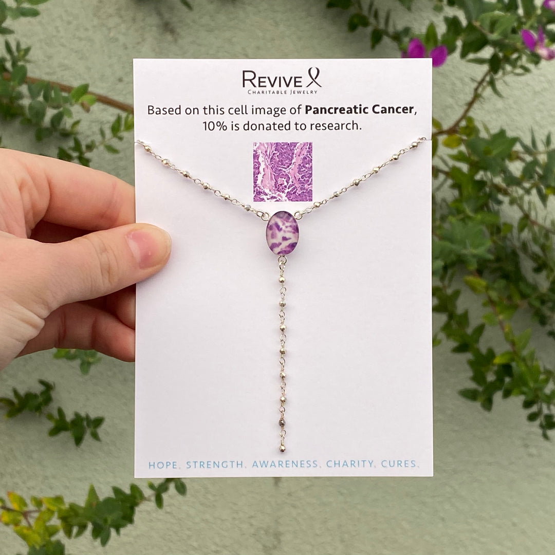 y necklace for pancreatic cancer with cell image resin pendant and rosary style silver pyrite linked chain on product packaging