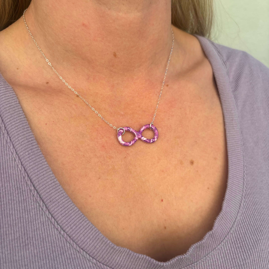 model wearing infinity pendant necklace with pancreatic cancer cell image in resin on Sterling silver adjustable chain 