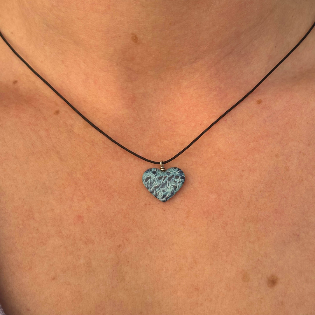 model wearing heart shaped necklace with ovarian cancer awareness cell image in resin pendant on adjustable black cord