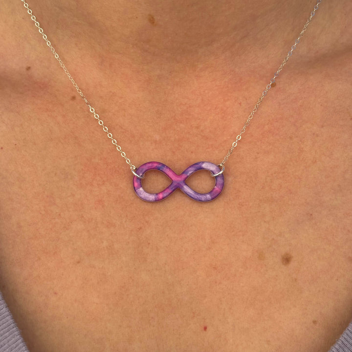 close up of model wearing infinity pendant necklace with lung cancer cell image in resin on Sterling silver chain 