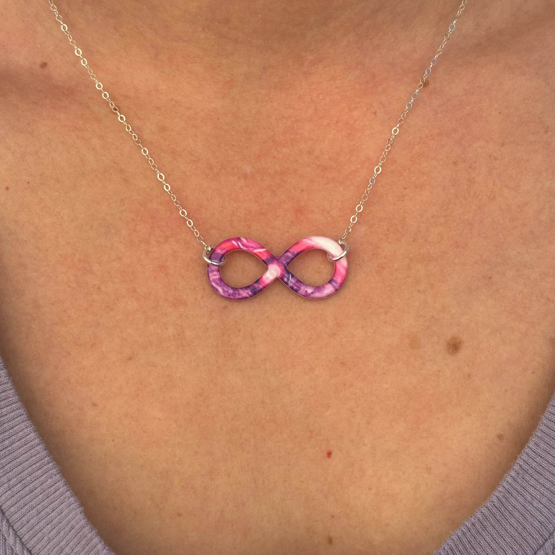 close up of model wearing infinity pendant necklace with lupus cell image in resin on Sterling silver chain 