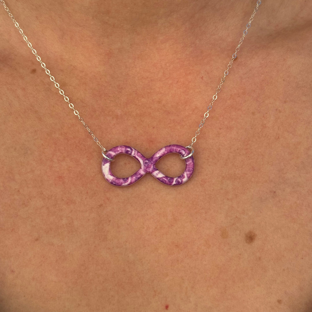 close up of model wearing infinity pendant necklace with pancreatic cancer cell image in resin on Sterling silver adjustable chain