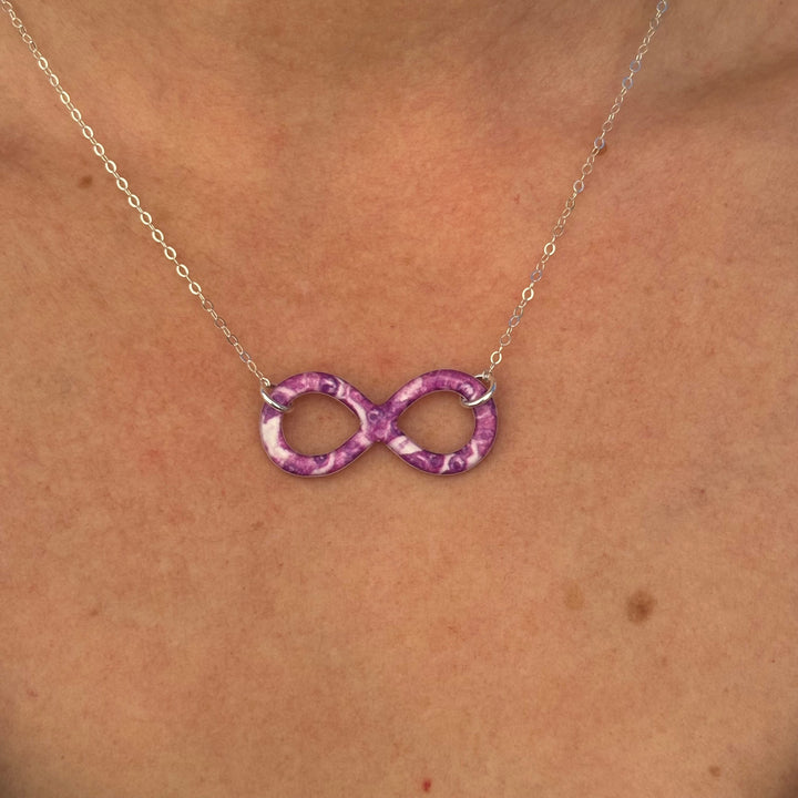 close up of model wearing infinity pendant necklace with pancreatic cancer cell image in resin on Sterling silver adjustable chain