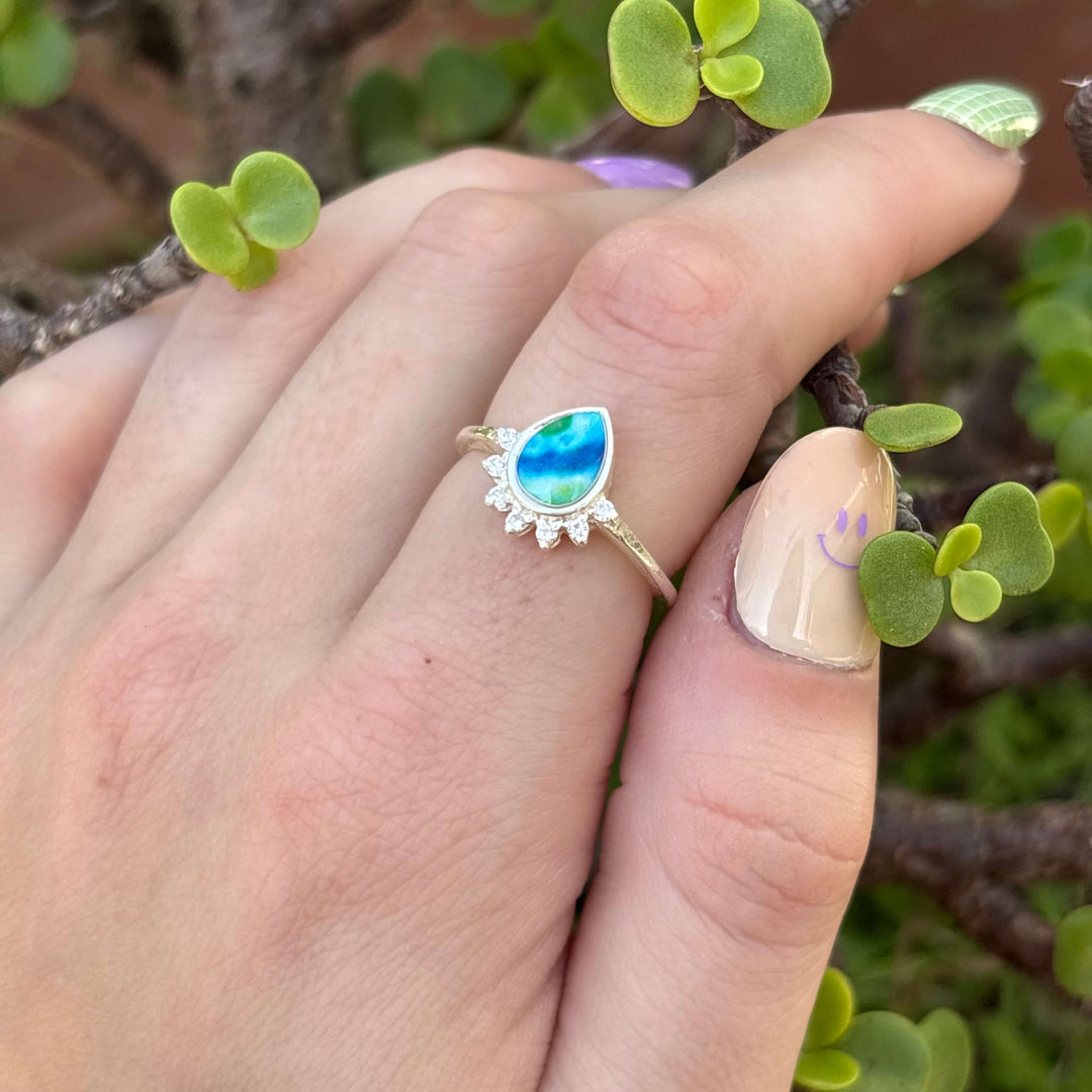 Sterling silver teardrop shaped ring with half halo of cubic zirconia stones and diabetes cell image under resin pendant on model