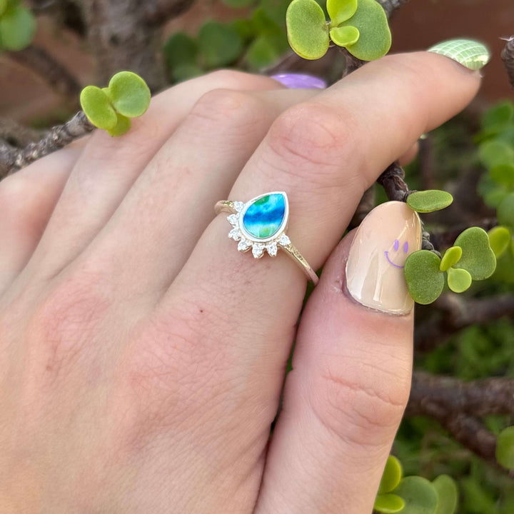 Sterling silver teardrop shaped ring with half halo of cubic zirconia stones and diabetes cell image under resin pendant on model