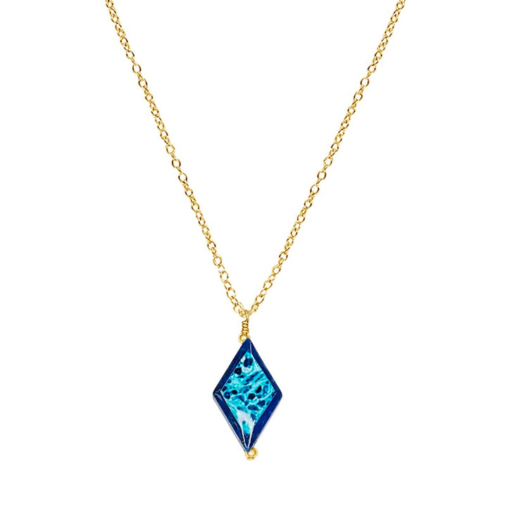 close up of diamond shaped dark blue lapis stone pendant necklace on gold filled chain featuring ovarian cancer cell image in resin