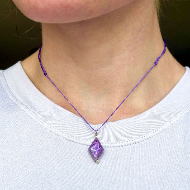 model wearing diamond shaped lepidolite stone pendant necklace on purple cord featuring pancreatic cancer cell image in resin