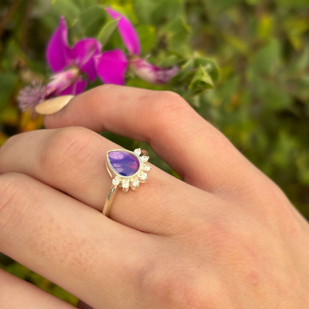 Sterling silver teardrop shaped ring with half halo of cubic zirconia stones and lung cancer cell image under resin pendant on model