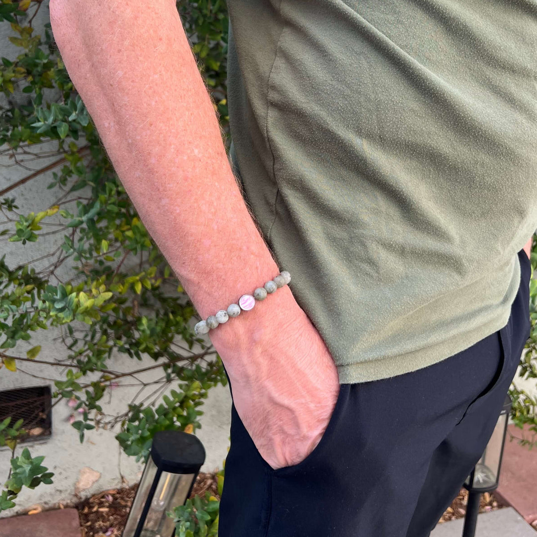 model wearing mens breast cancer bracelet with matte labradorite stones on stretch cord and cell image in resin pendant