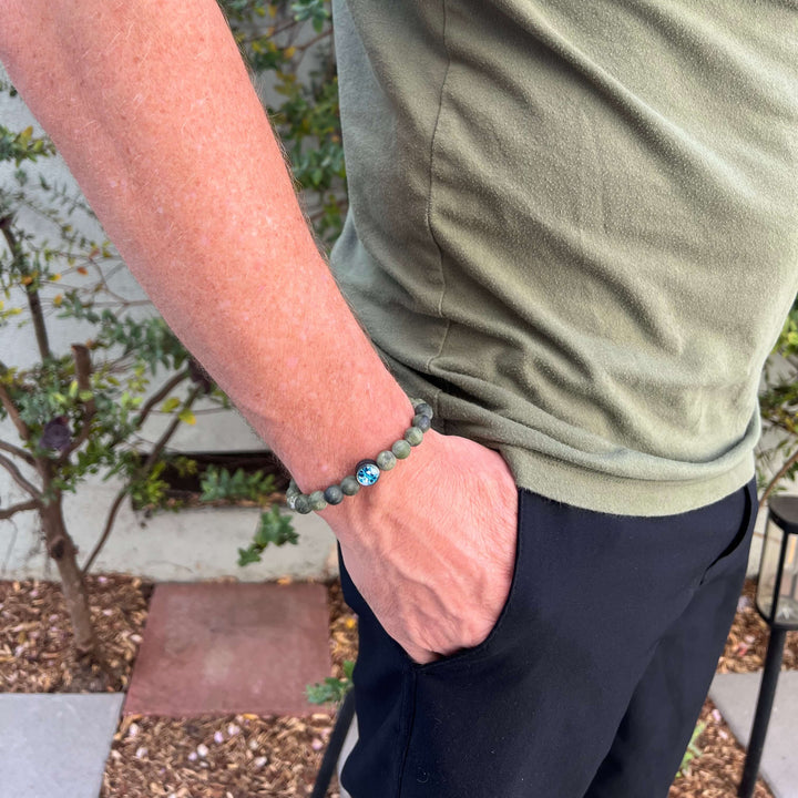 model wearing mens jade bracelet with ovarian cancer cell image in resin pendant on stretch cord