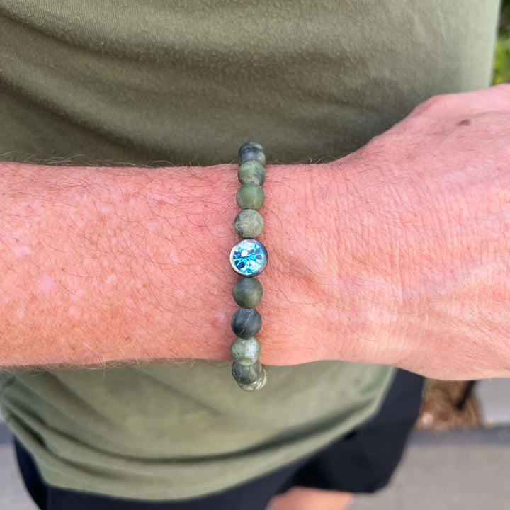 close up of man wearing mens jade bracelet with ovarian cancer cell image in resin pendant on stretch cord