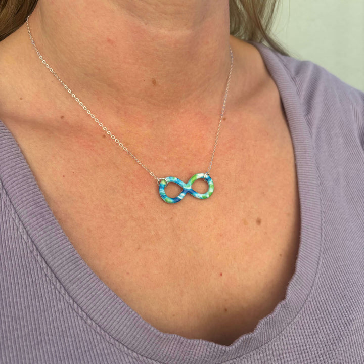 model wearing infinity symbol pendant with diabetes cell image in resin and sterling silver chain