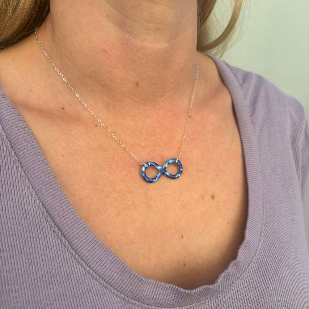 model wearing childhood cancer cell image infinity symbol pendant with resin and Sterling silver chain necklace