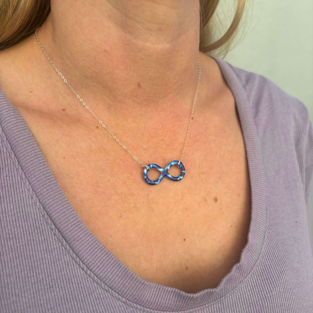 model wearing childhood cancer cell image infinity symbol pendant with resin and Sterling silver chain necklace
