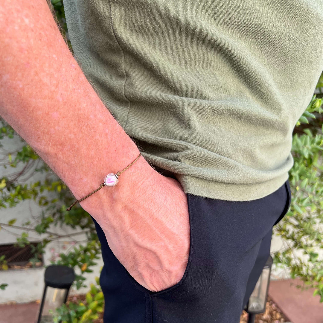 model wearing mens Sterling silver breast cancer cell image in resin pendant on brown adjustable cord