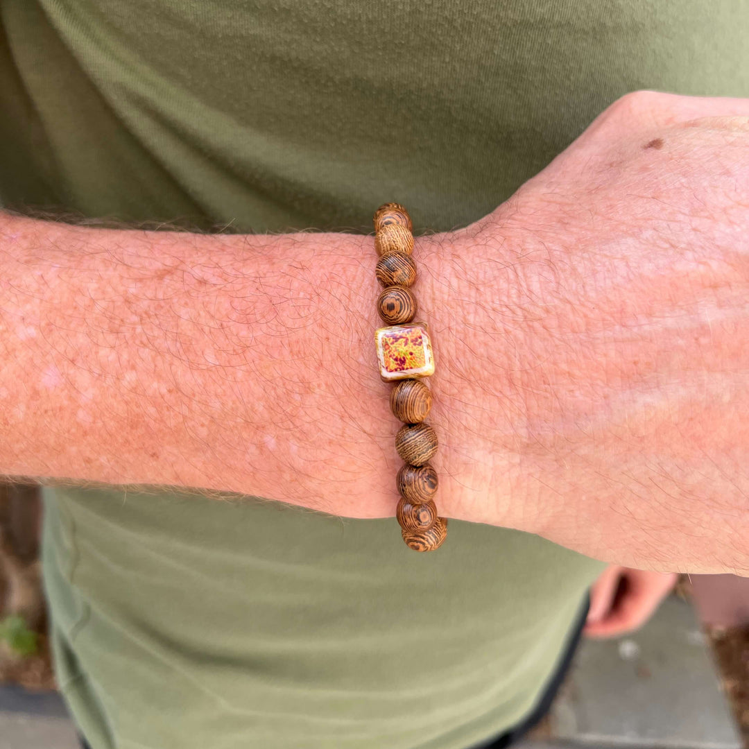 close up of model wearing wood bracelet for men based on a prostate cancer cell image in resin on stretch cord