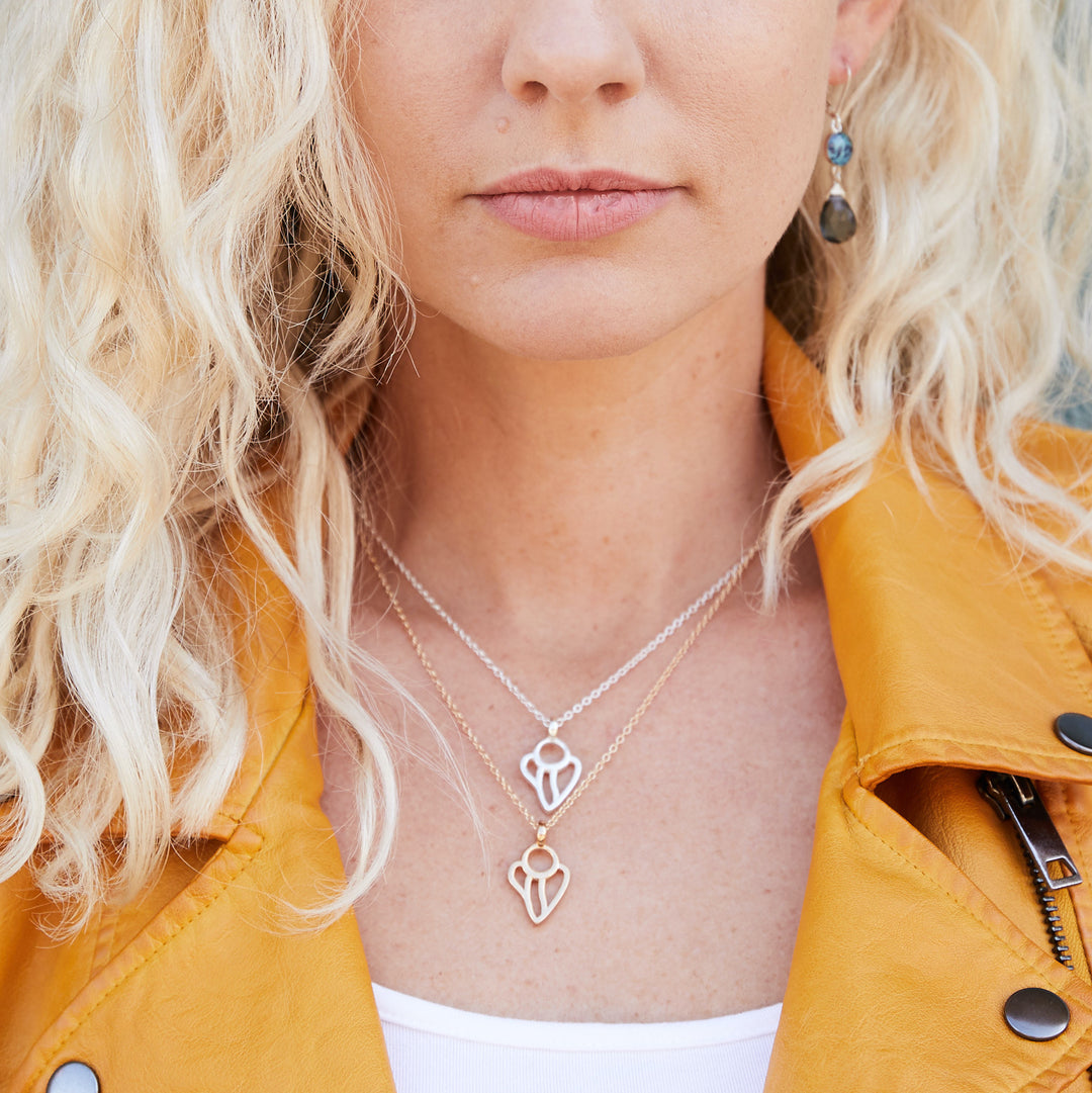 Model wearing silver and gold guardian angel lung cancer necklace.