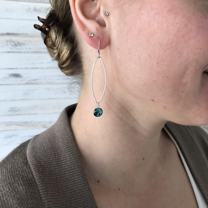 Model wearing Teal ovarian cancer earrings in sterling silver. 
